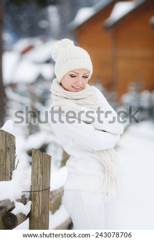 Beautiful winter portrait of young woman in the winter snowy scenery. Young woman winter portrait. Shallow dof. Snow winter woman portrait outdoors on snowy white winter day.