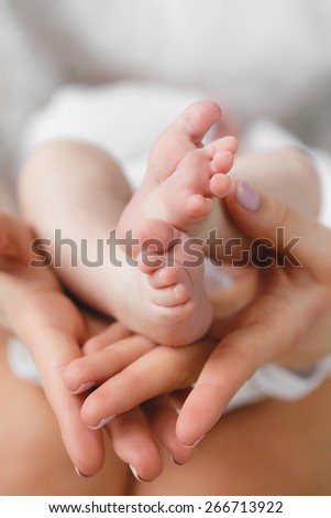 Newborn baby feet in mother hands.Masseur massaging little baby\'s foot, shallow focus. Newborn baby feet in mother\'s hands.Mother making massage of child\'s foot