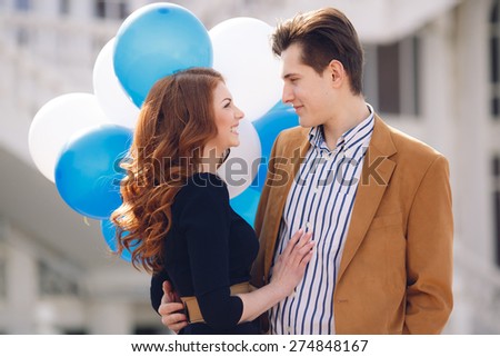 holidays, celebration and dating concept - couple with colorful balloons in the city. Happy couple with colorful balloons outdoors.