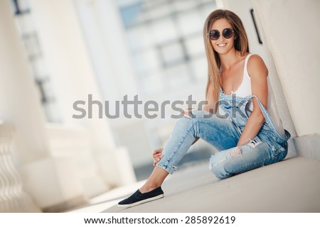Young smiling woman outdoors portrait. Soft sunny colors.Close portrait. beautiful smiling girl. Woman in the city in summertime. Summer outdoor portrait