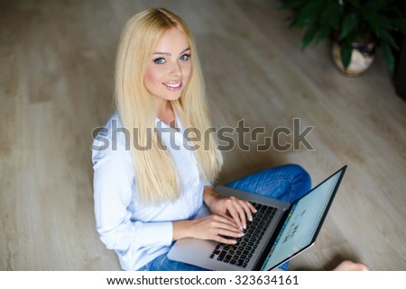 Woman with laptop at home. Top view. Young woman with laptop on the floor. Woman websurfing on the net with laptop. happy young beautiful woman with laptop - indoors