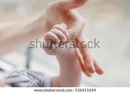 Mother holding her child's hand. baby holding his mother's big finger. mother and baby's hand. tenderness and love