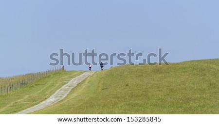 view from the south downs way footpath, sussex, england uk - fit senior couple cycling up a hill on mountain bikes