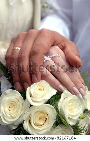 wedding rings on the groom and bride with beautiful nails and flowers