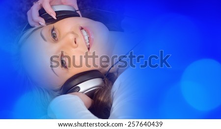 Young woman listening to music blue defocused lights