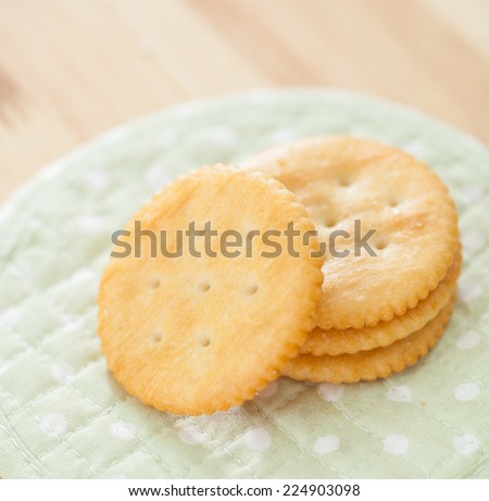 Round salty crackers on white dot green fabric  background