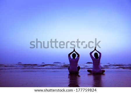 family yoga on the beach at sunset