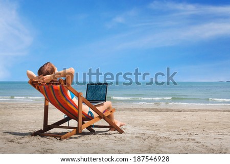 happy woman with laptop on the beach