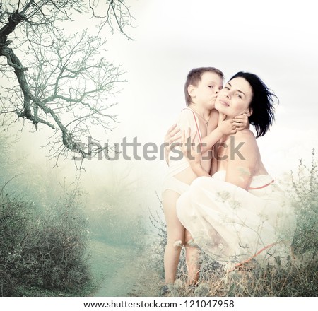 Beautiful young woman hugging her pretty child boy in foggy misty forest. White background, place for text. Poster, card. Seasonal - autumn, winter. Family, love, mother, feelings.