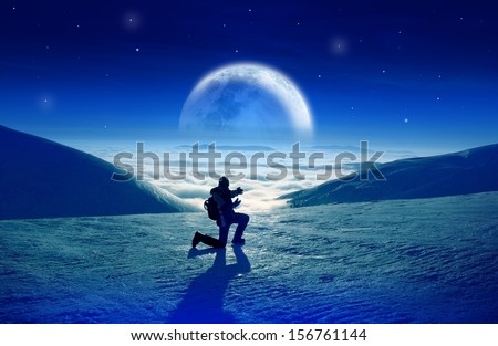 Man tourist showing fantastic high mountains landscape with beautiful moon over the clouds