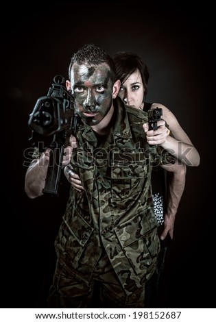 Spanish military with SMG and girl with gun on black background