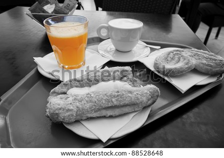 Breakfast with coffee, juice and pastries in black and white and selective de-saturation