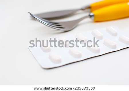 Dinner set with pills on white background.