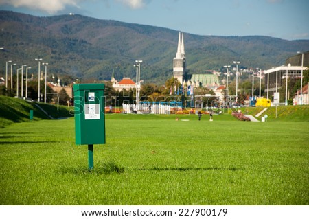 Zagreb, Croatia - October 18, 2014: Bright green dog mess poop bin with label.