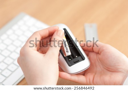 Zagreb, Croatia - January 31, 2015: Changing batteries on a wireless computer mouse.