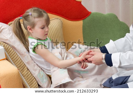 doctor taking pulse of 4 years old girl at home