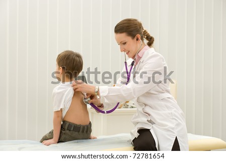 woman doctor listening to heartbeat of 4 years old boy in office