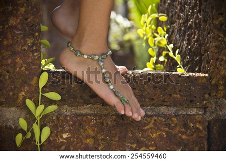 Female feet on stone step with bracelet on ankle