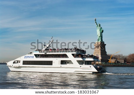 NEW YORK - NOVEMBER 25: Luxury yacht Zephyr filled with tourist  in front of Statue of Liberty on November 25, 2011. Zephyr departs from South Street Seaport for Statue of Liberty Express tours.