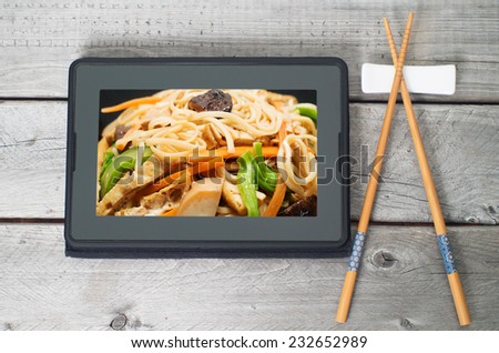 On-line and web asian food ordering concept with digital table and chopsticks