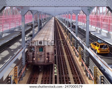 NEW YORK, NY, USA - SEPTEMBER 14, 2013: Subway train and yellow cab pass each other on the Williamsburg Bridge in New York, NY, USA on September 14, 2013.