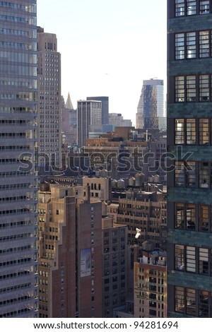 View through a gap between Manhattan skyscrapers, over New York city with a golden sparkle.