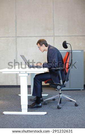 short-sighted business man bad sitting posture at laptop .