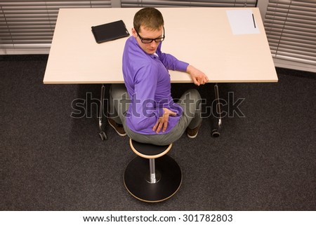 man exercising during short break in work at his desk in office