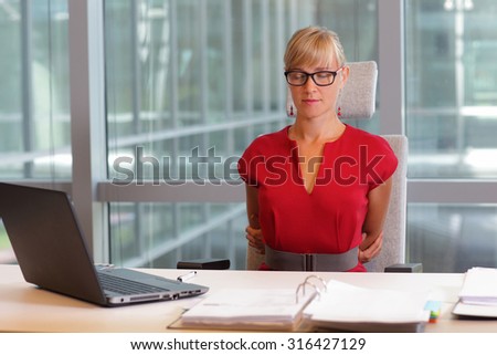 caucasian business woman in eyeglasses relaxing, stretching back - short break for exercise on chair  in office