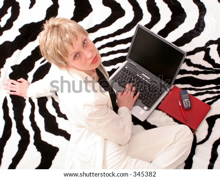 On-line everywhere - unique .Businesswoman with cellular phone and calender  working on laptop