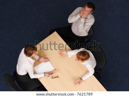 Man covers face with hand. his wife is screaming to therapist.Young couple having psychotherapy,Aerial shot taken from directly above the table.