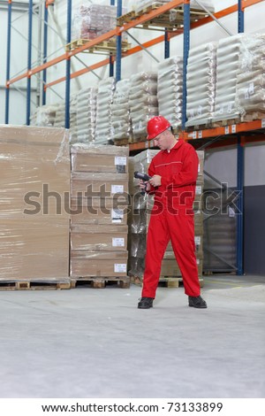 worker in red uniform with bar code reader preparing to work in warehouse