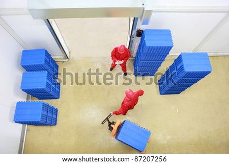 goods delivery in storehouse - overhead view of two workers working in small warehouse