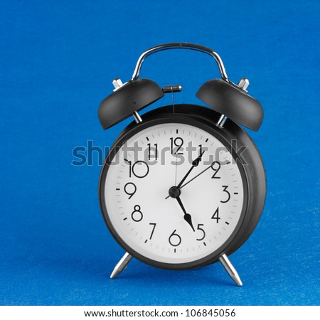 Old-fashioned alarm clock isolated on a blue background