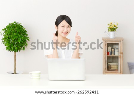 Japanese woman thumbs up gesture with PC