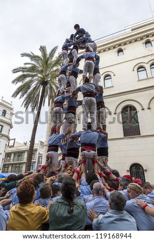 BARCELONA - NOVEMBER 18: Some unidentified people called Castellers do a Castell or Human Tower, typical tradition in Catalonia, on November 18, 2012 in Barcelona, Spain.