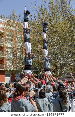 SANT CUGAT, SPAIN - APRIL 07: Some unidentified people called Castellers do a Castell or Human Tower, typical tradition in Catalonia, on April 07, 2013 in Sant Cugat, Spain.