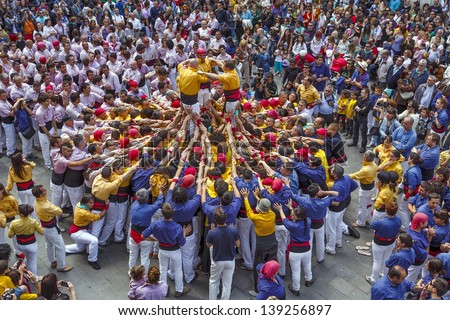 BARCELONA, SPAIN - MAY 19: Some unidentified people called Castellers do a Castell or Human Tower, typical tradition in Catalonia, on May 19, 2013 in Barcelona, Spain.