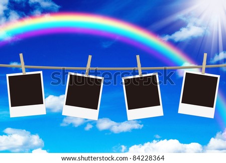 blank photo frames hanging against rainbow sky