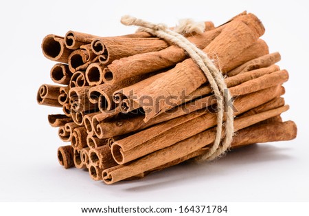 A heap of bound-up big cinnamon sticks on white background
