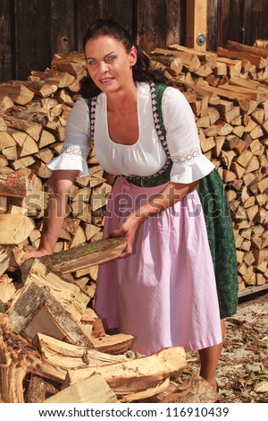 Farmer stacked wood for the coming winter /Woman in wood piles