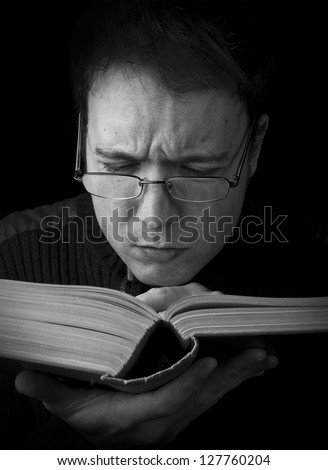 man studying, male with glasses reading book black and white portrait