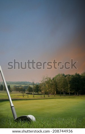 chipping a golf ball onto the green with golf club at sunset with copy space, portrait format