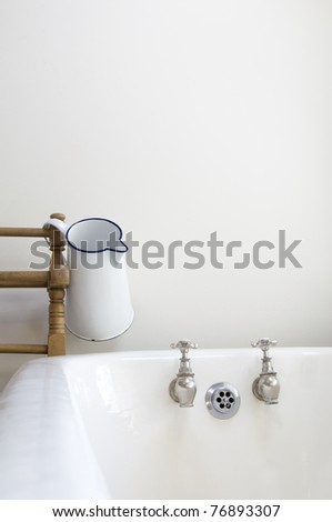 an old fashioned bathroom with bath and water jug