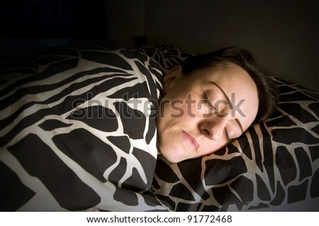 woman asleep in bed with black ans white sheets
