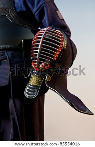 Kendo fighter posing with helmet in his hand - detail
