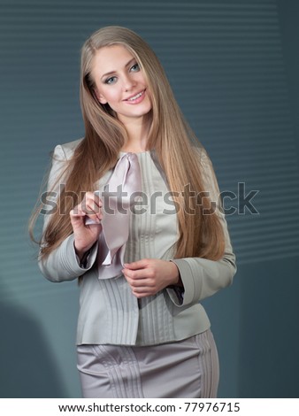 beautiful woman in a gray suit against a dark background in the office