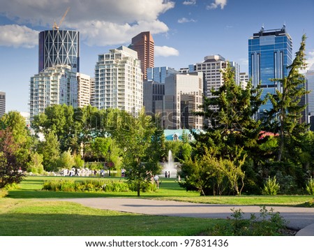 Beautiful sunny summer day in Calgary Downtown. Beautiful view of downtown of the biggest Alberta city - Calgary. Image taken from Prince\'s Island park with it\'s fountains and mature trees.