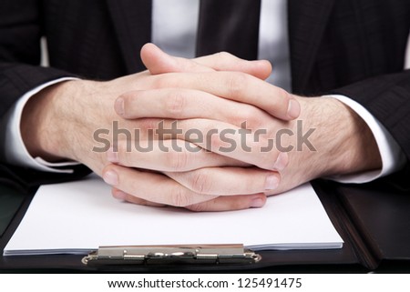 Businessman at the office with his hands folded