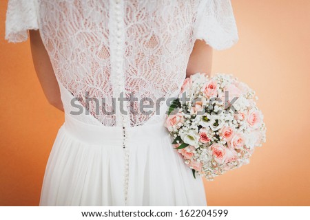 bride holding a wedding bouquet and turning back to the camera